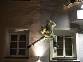 scalatore su un' edificio arrampicata a notte foto