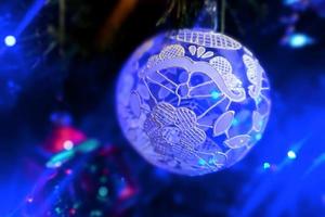 bicchiere mano fatto Natale palla su natale albero dettaglio sfocatura luci foto