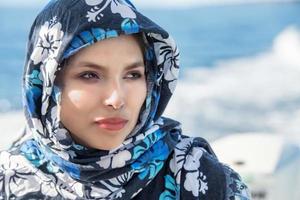 bellissimo donna Arabo vestito ritratto su mare sfondo foto