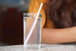 freddo acqua bicchiere su il tavolo foto