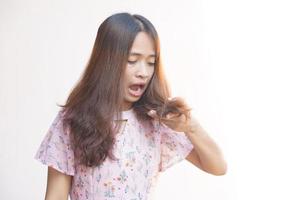 asiatico donna scioccato per vedere danneggiato capelli foto