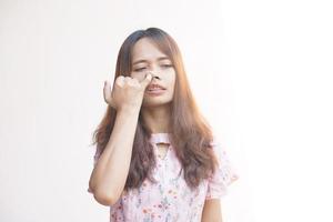 asiatico donna rosicchiare sua naso con sua dito foto