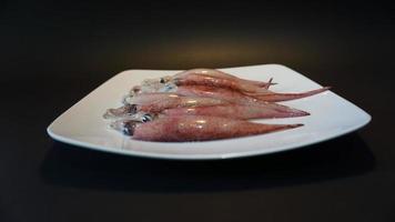 calamaro frutti di mare su un' piatto su un' nero sfondo. foto