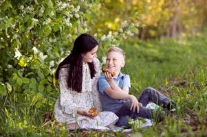 carino bambino ossequi mamma per picnic cibo foto