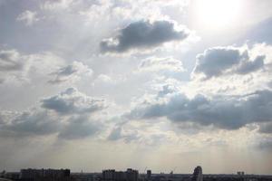 tramonto cielo sopra pesante buio nuvole quasi pioggia con drammatico raggi di leggero splendente giù sfondo e città sera tempo foto