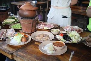 tailandese caldo pentola ricetta jim jum, argilla pot.thai tradizionale speziato shabu Shabu, immersione carne nel bollito speziato la minestra. foto