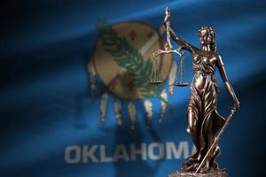 Oklahoma noi stato bandiera con statua di signora giustizia e giudiziario bilancia nel buio camera. concetto di giudizio e punizione foto