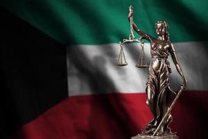 Kuwait bandiera con statua di signora giustizia e giudiziario bilancia nel buio camera. concetto di giudizio e punizione foto