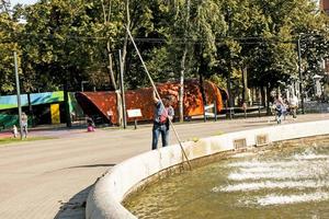 pulizia fontane nel il città. un' uomo pulisce un' Fontana nel un' parco nel il città centro su un' soleggiato giorno. foto