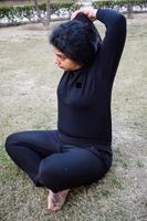 giovane indiano donna praticante yoga all'aperto nel un' parco. bellissimo ragazza pratica di base yoga posa. quiete e relax, femmina felicità. di base yoga pose all'aperto foto