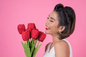 ritratto di una bella donna con bouquet di fiori di tulipano rosso