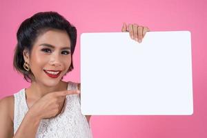 ritratto di una donna alla moda che mostra uno striscione bianco foto