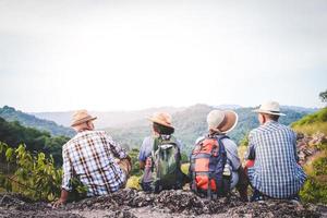 un' gruppo di asiatico gli anziani escursioni a piedi e in piedi su alto montagne godendo natura. anziano Comunità concetti foto