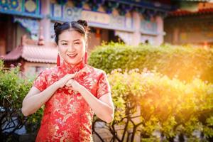 asiatico donne indossare rosso cheongsam per congratularsi il Cinese nuovo anno. nuovo anno celebrazione 2020 foto
