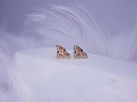 bellissimo oro orecchini avvicinamento su un' bianca sfondo foto