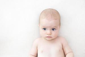 bambina carina sdraiata sul letto foto