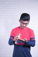 giovane uomo asiatico utilizzando liquido disinfettante per prevenire il virus corona foto