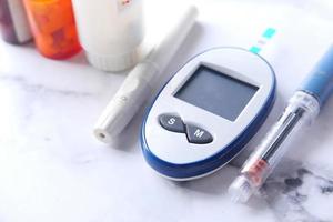 Close-up di strumenti di misurazione del diabete, insulina e pillole su sfondo bianco