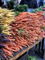 un mucchio di carote colorate in una piazza del mercato