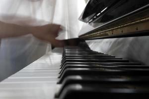 mani giocando pianoforte mentre in movimento foto