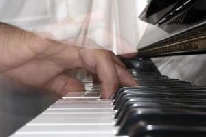 mani giocando pianoforte mentre in movimento foto