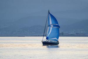 piccolo barca a vela a tramonto foto