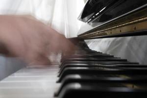 mani giocando pianoforte mentre in movimento foto