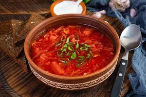 tradizionale ucraino borscht con verde cipolla e acida crema. delizioso barbabietola la minestra nel ciotola con segale pane foto