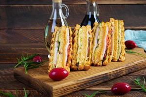 club Sandwich con prosciutto, formaggio, pomodoro e insalata. grigliato Sandwich con secco pomodori pane foto