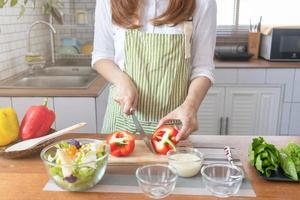 giovane donna preparazione campana Pepe come un' prima colazione ingrediente e pronto per salutare cucinando e su il tavolo Là siamo verdure quello siamo salutare biologico ingredienti. salutare cibo preparazione idee foto