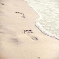 impronte su una spiaggia tropicale foto