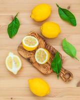 limoni e foglie di limone su fondo di legno rustico