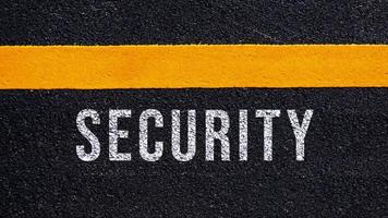 sicurezza testo scritto e giallo linea su il strada nel mezzo di il asfalto strada, sicurezza parola su strada. foto