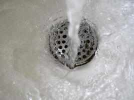 acqua fluente risciacquo in esecuzione nel il Lavello gocce spray foto