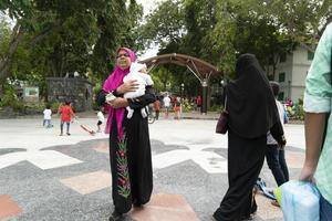 maschio, Maldive - febbraio 16 2019 - persone e bambini nel isola principale posto prima sera pregare tempo foto