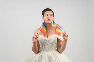 giovane asiatico bellissimo sposa con arcobaleno bandiera su bianca sfondo foto