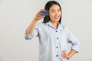 ritratto di positivo giovane asiatico donna mostrando credito carta bene umore stipendio isolato su bianca sfondo foto