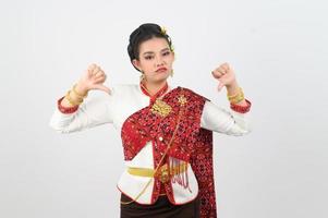 giovane bellissimo donna nel tailandese lanna costume con pollice giù posizione foto