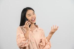 protrait di giovane asiatico donna parlando su mobile Telefono mentre in piedi isolato al di sopra di bianca sfondo foto