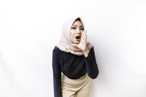 giovane bellissimo asiatico musulmano donna indossare un' hijab urlando e urlando forte con un' mano su sua bocca. comunicazione concetto. foto