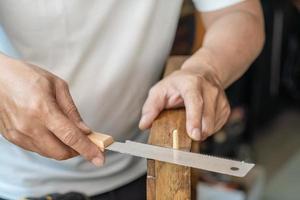 falegname utilizzando giapponese sega o Tirare sega , taglio di legno Perni su legna su tavolo , Fai da te creatore e la lavorazione del legno concetto. selettivo messa a fuoco foto