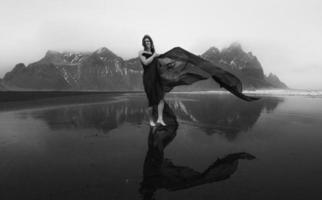 elegante donna con agitando grotta su spiaggia monocromatico panoramico fotografia foto