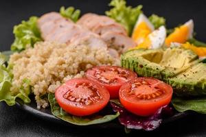 delizioso salutare pranzo consistente di pollo, avocado, quinoa, uova e pomodori foto