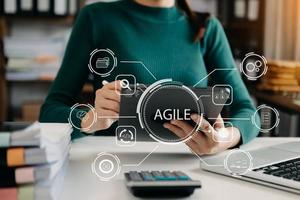 agile sviluppo metodologia concetto. attività commerciale mano utilizzando il computer portatile e tavoletta con virtuale schermo agile icona su moderno ufficio digitale tecnologia concetto. foto