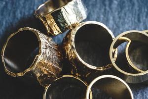 diversi anelli d'oro ammucchiati su una tavola di ardesia