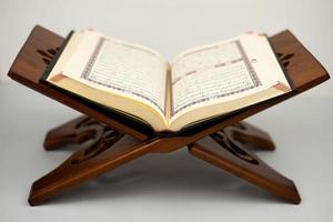 Aperto santo Corano su tradizionale di legno tavolo foto