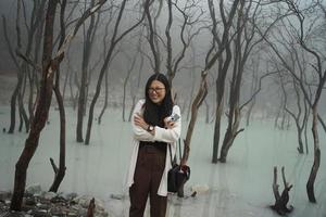 asiatico donne viaggiatore in piedi nel bianca cratere, ciwidey, bandung, ovest Giava, Indonesia. foto