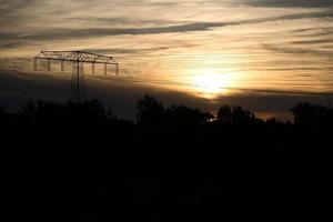 alta tensione energia polo con alto linea attraverso quale il elettricità è trasportato foto