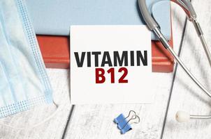 stetoscopio e bianca carta con vitamina b12 testo su taccuino foto