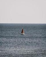 barca a vela in mare durante il giorno foto